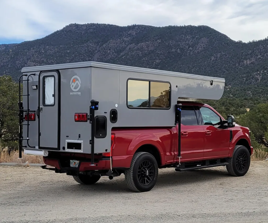 Apex 8 outfitter truck bed camper loaded on a red truck 