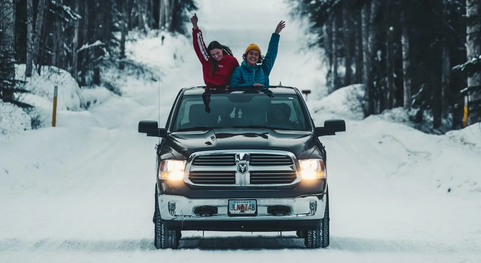 two friends enjoying winter on truck
