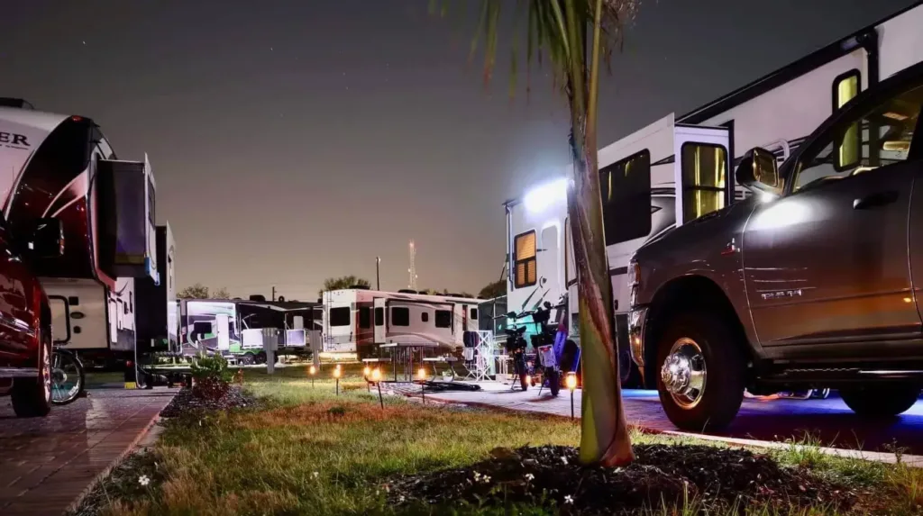 rvs, trucks and cars parked in the rv parks at night
