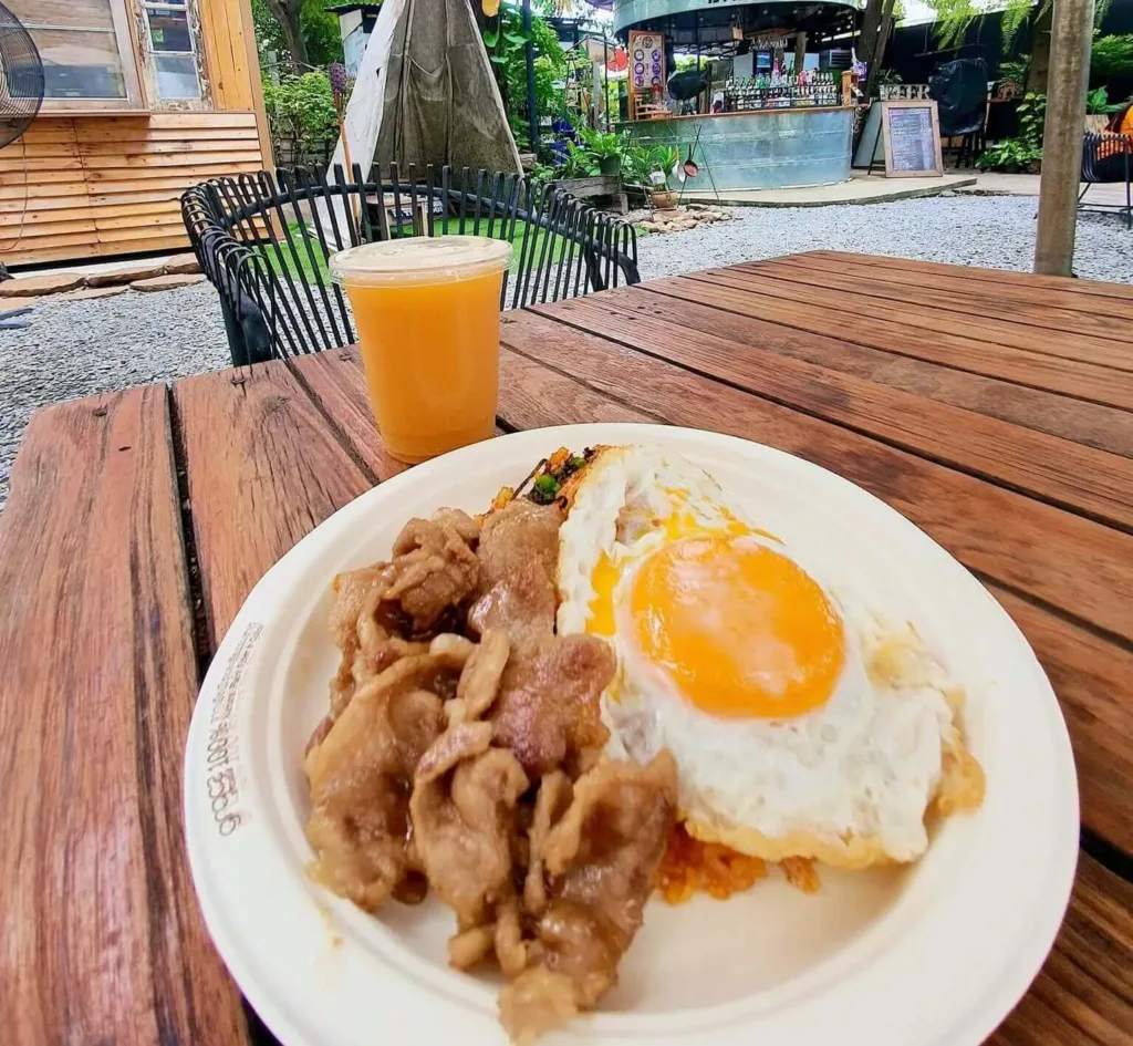 plate on a table with egg and bacons and a glass of orange juice. showcasing camping food ideas for breakfast
