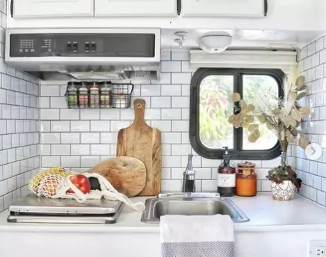 Kitchen interior of a truck camper with white reusable tiles